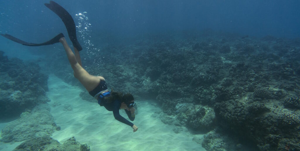 woman freediving with-flippers underwater
